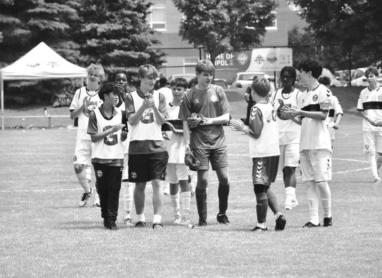 A youth soccer player performing dynamic warm-ups on a pitch in Hamilton.