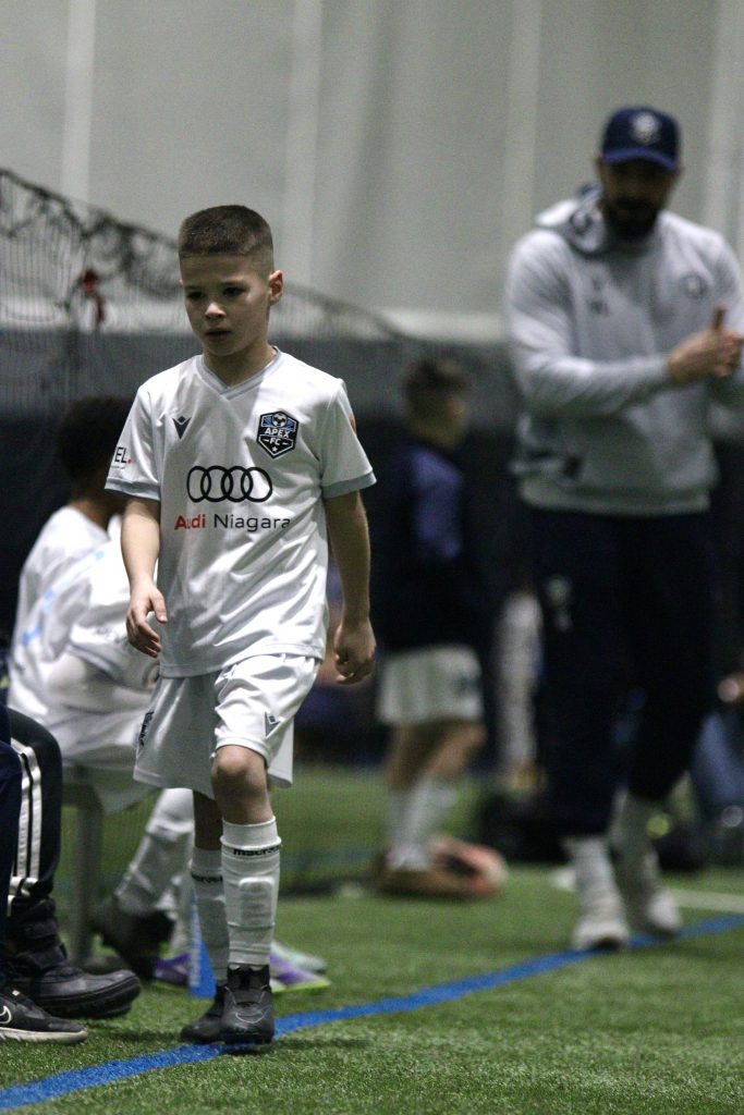 youth soccer player approaching bench