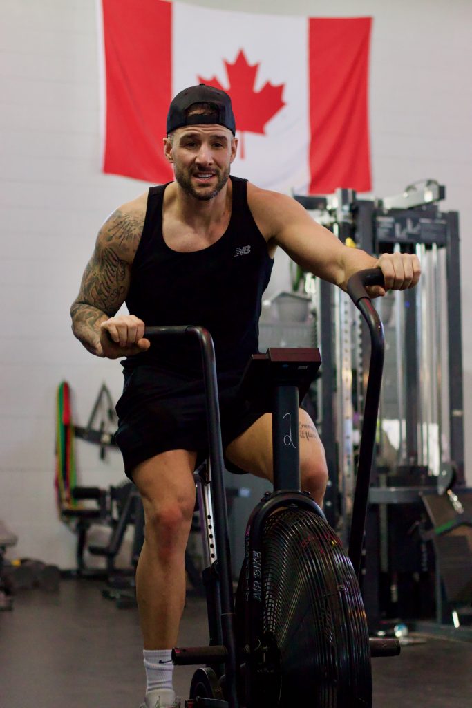 Athlete performing a high-intensity lift in the gym while listening to high-tempo hip hop.